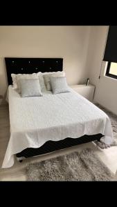 een slaapkamer met een groot bed met witte lakens en kussens bij Apart Centro Acomoda 10 in Curitiba