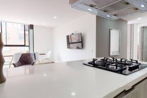 uma cozinha com uma placa de fogão numa cozinha branca em Apartamento 2 habitaciones Unicentro Scape em Bogotá