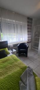 1 dormitorio con 1 cama verde y 1 sofá en Hotel Zur Aue, en Wesel