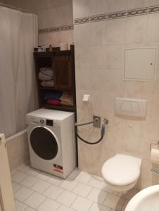 uma casa de banho com uma máquina de lavar roupa e um WC em Ferienwohnung neben HBF em Gera