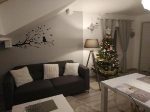 una sala de estar con un árbol de Navidad y un sofá en Gîte l'Améthyste 3 appartements, en Gérardmer