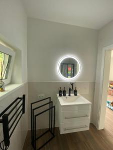een badkamer met een witte wastafel en een spiegel bij Ferienwohnung Niederlaasphe in Bad Laasphe