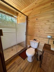a wooden bathroom with a toilet and a shower at Chalet VIP reservado Jacuzzi in Subachoque