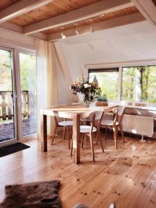comedor con mesa de madera y sillas en A Wood Lodge - zwembad - relax - natuur, en Durbuy
