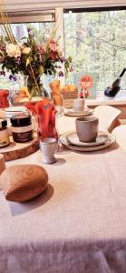 uma mesa com pratos e copos e uma colher de madeira em A Wood Lodge - zwembad - relax - natuur em Durbuy