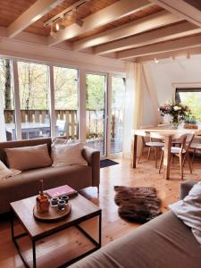 sala de estar con sofá y mesa en A Wood Lodge - zwembad - relax - natuur, en Durbuy