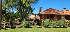 uma casa com uma cerca em frente a um quintal em Chales Encanto Suíço em Monte Verde