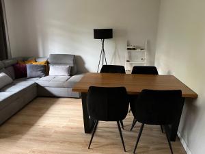 オストロビエツ・シフィエントクシスキにあるKomfortowe mieszkanieのリビングルーム(テーブル、椅子、ソファ付)