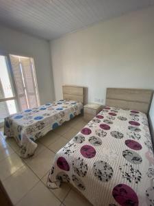 een slaapkamer met 2 bedden in een kamer bij Casa Bellatorres in Passo de Torres