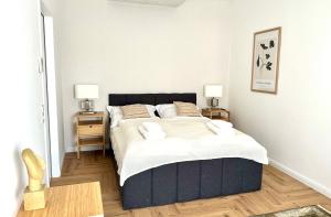 una camera da letto con un grande letto con due comodini di MIRABELLE Homes a Salisburgo