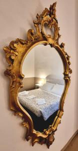 a mirror on a wall with a bed in it at Dimora Montecchi in Verona