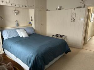 a bedroom with a bed with a blue blanket at Magical, Stylish, Comfortable, Brilliant Location in Kent