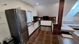 una cucina con frigorifero in acciaio inossidabile in una camera di Penzion Mivex a Kráľová Lehota