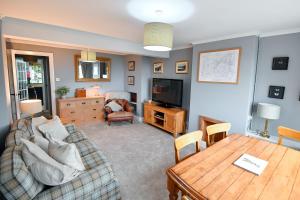a living room with a couch and a table at Charming Malvern Cottage with Outstanding Views in Malvern Wells