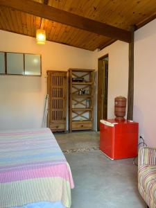 1 dormitorio con cama y techo de madera en Apartamentos com cachoeira no quintal, en Ilhabela