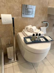 a bathroom with a toilet with towels and a tray on it at Luxury Studio Apartment The Cube Birmingham City Centre in Birmingham