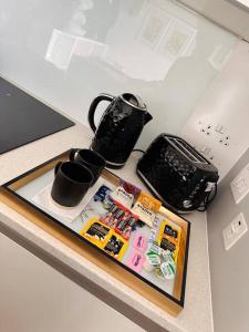 a table with a tray with cups and other items on it at Luxury Studio Apartment The Cube Birmingham City Centre in Birmingham