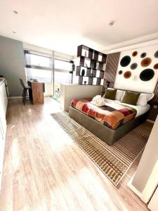 a bedroom with a large bed and a wooden floor at Luxury Studio Apartment The Cube Birmingham City Centre in Birmingham