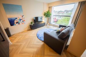 ein Wohnzimmer mit einem Sofa und einem großen Fenster in der Unterkunft Joyful Serviced Studio Apartment -KS71-J in Hilversum