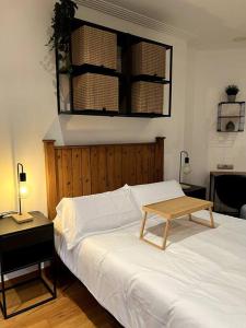 a bedroom with a bed with a table on it at Central Suites Poli Sanz in Vigo +8 photos