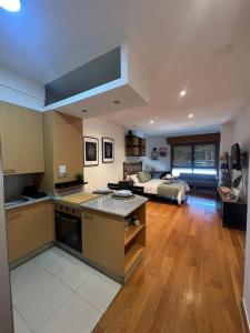 a large kitchen and living room with a bed at Central Suites Poli Sanz in Vigo