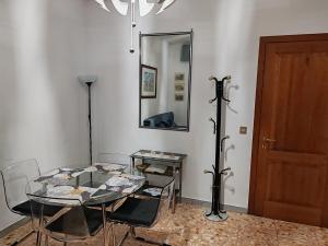 uma sala de jantar com uma mesa de vidro e um espelho em In the Heart of Rome em Roma