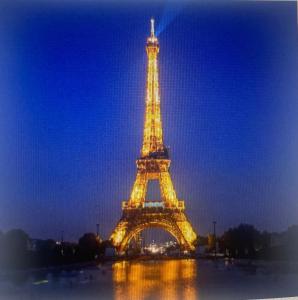 una imagen de la torre Eiffel iluminada por la noche en Le refuge coloré à l'entrée de Paris, en Bobigny