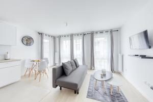 a white living room with a couch and a table at Superbe T2 proche Paris métro 7 à 5 mn à pied in Ivry-sur-Seine