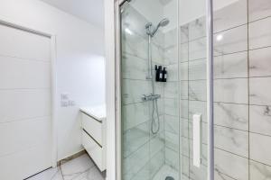 La salle de bains blanche est pourvue d'une douche et d'un lavabo. dans l'établissement Superbe T2 proche Paris métro 7 à 5 mn à pied, à Ivry-sur-Seine