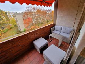 balcón con banco, silla y ventana en 2-Zimmer Messe-Apartment Nbg-Langwasser 60qm en Núremberg