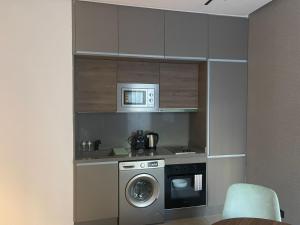 a kitchen with a washing machine and a microwave at Magic Appartement Luxury Gauthier 04 in Casablanca