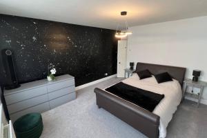 a bedroom with a bed and a black wall at Cosy Corner in Midhurst