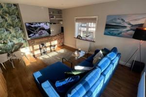 a living room with a blue couch and a table at Cosy Corner in Midhurst