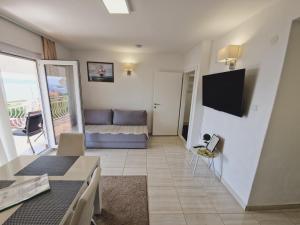 a living room with a couch and a television at Apartmani Kristijan - Sea view Studio Apartmant 3 in Crikvenica