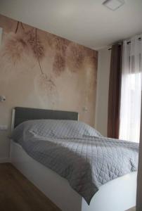 - une chambre avec un lit et un mur orné d'une fresque murale représentant un insecte dans l'établissement Niechorze Modrzewiowa Apartament, à Niechorze