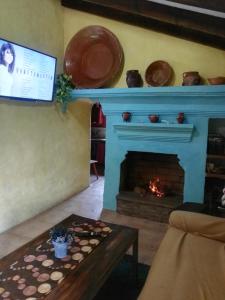 salon z niebieskim kominkiem i stołem w obiekcie Pinar El Almendra w Maladze