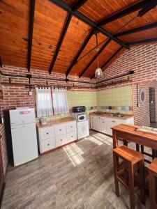 賈爾迪諾別墅的住宿－Valle Verde，一间厨房,配有白色家电和木制天花板