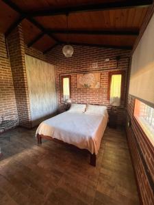 賈爾迪諾別墅的住宿－Valle Verde，卧室设有一张砖墙内的大床