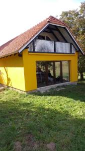 ein gelbes Haus mit einem großen Fenster auf einem Feld in der Unterkunft Viata Naturala Green Life in Gălăşeni