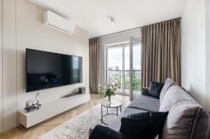 a living room with a couch and a flat screen tv at SKY Home- Angel Apartament -Neopolis, Centrum, Parking, Klimatyzacja, Dostęp na Kod in Łódź