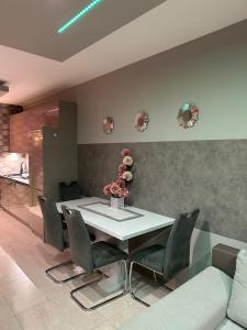 a dining room with a white table and chairs at NEW APARTMAN in Debrecen