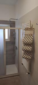 baño con ducha y puerta de ducha de cristal en DA VINCI AFFITTACAMERE BORGO, en Taranto