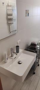 bagno con lavandino bianco e specchio di DA VINCI AFFITTACAMERE BORGO a Taranto