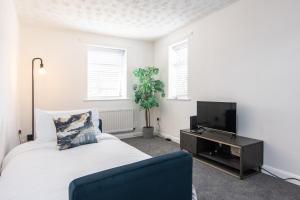 a bedroom with a bed and a tv at South Street Apartments in Derby