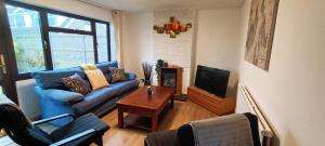 uma sala de estar com um sofá azul e uma televisão em Grace's Place in Soham em Soham