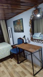 a bedroom with a table and a bed and a mirror at Natural Pacific Suites in Manuel Antonio