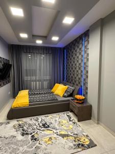 a bedroom with a large bed with yellow pillows at NEW APARTMAN in Debrecen