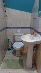a bathroom with a toilet and a sink at Natural Pacific Suites in Manuel Antonio