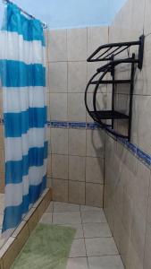 a shower with a blue and white curtain in a bathroom at Natural Pacific Suites in Manuel Antonio