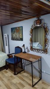 曼努埃爾安東尼奧的住宿－Natural Pacific Suites，配有桌子、镜子和床的房间